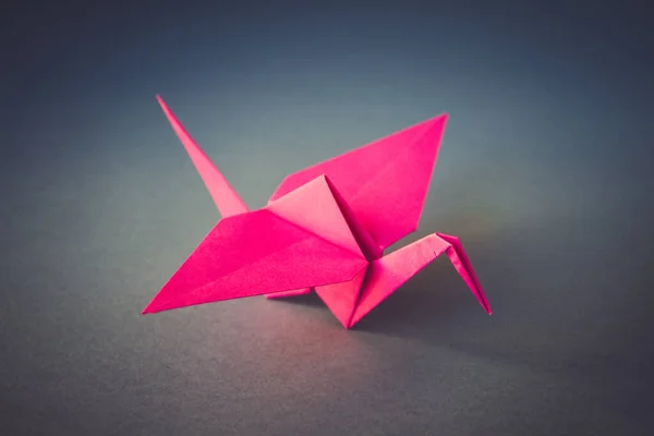 Roze Papieren Kraan Origami Geïsoleerd Een Blanco Grijze Achtergrond — Stockfoto