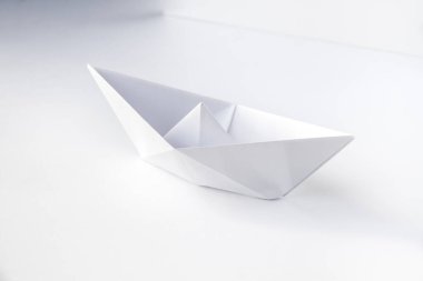 Kağıt tekne origamisi boş bir arkaplanda izole edildi.