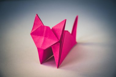 Pembe kağıt kedi origamisi boş beyaz bir arkaplanda izole edilmiştir..