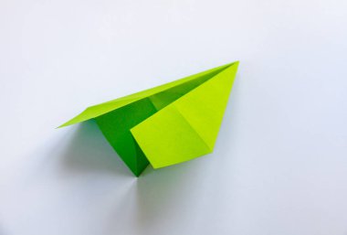 Yeşil kağıt uçak origamisi boş beyaz bir arkaplanda izole edildi