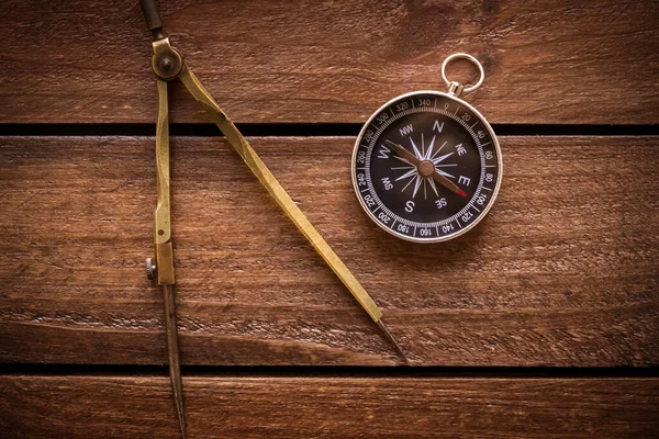 Vintage drawing and navigational Compass on a rustic wooden board
