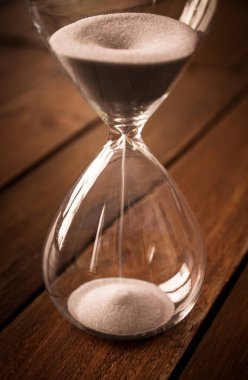 Kırsal ahşap arka planda beyaz kum içeren kum saati.