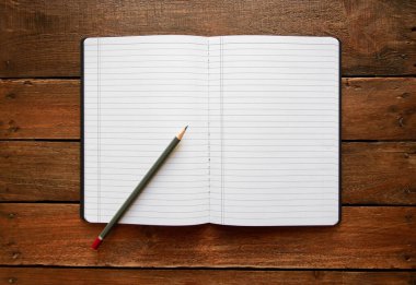 Kırsal bir ahşap tahtanın üzerinde defter ve kalem aç