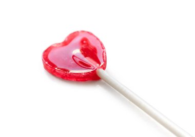 Parlak kırmızı kalp şekilli lolipop beyaz arka planda izole edilmiş.