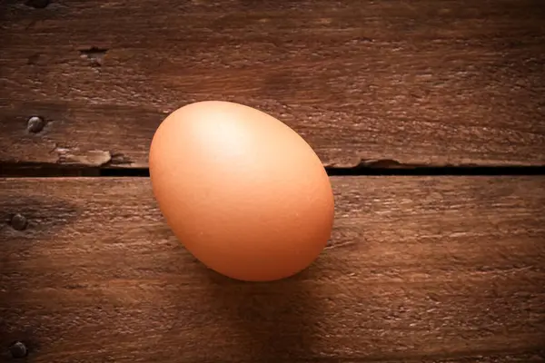 Fresh egg on a rustic wooden board background