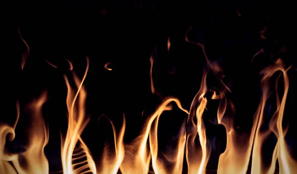 壁炉里的火焰 在黑色背景上孤立的纹理背景 免版税图库照片