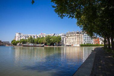 Paris - Fransa - Haziran 2023: Ourcq kanalı ve yaz aylarında bankalardan yüzen ev manzarası