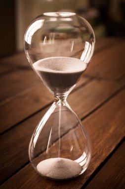 Kırsal ahşap arka planda beyaz kum içeren kum saati.