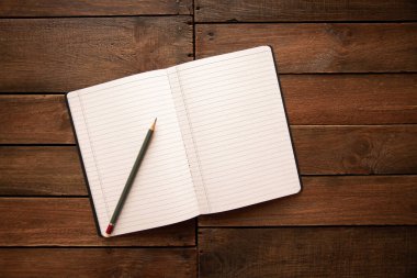 Kırsal bir ahşap tahtanın üzerinde defter ve kalem aç
