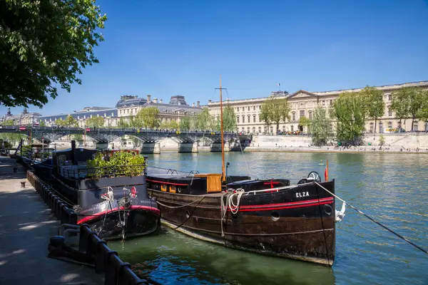 Paris - Fransa - 02 Mayıs 2023: Pont des arts, Louvre Müzesi ve Seine nehir kıyısından mavna manzarası