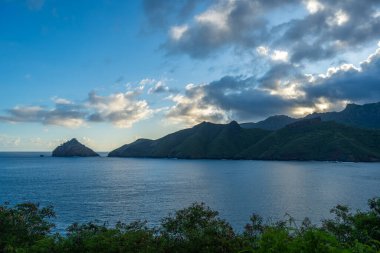 Marquesas Adaları 'ndaki Nuku Hiva' daki Taiohae Körfezi 'nin engebeli uçurumları parlak bir gökyüzünün altından çıkan küçük kayalık adalarla derin mavi Pasifik Okyanusu' na düşer. Fransız Polinezyası
