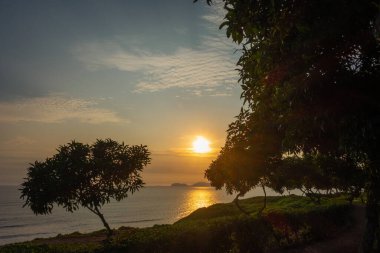 Güneş San Lorenzo adasının üzerinde batıyor, Pasifik Okyanusu 'na ve Peru' nun yeşil kayalıklarına altın bir parıltı saçıyor. Huzurlu kıyı manzarası doğanın güzelliğini ve huzurunu nefes kesici bir şekilde gösteriyor.