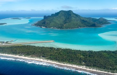 Fransız Polinezyası 'ndaki Maupiti Adası' nın çarpıcı hava manzarası turkuvaz sularını, yemyeşil suları ve adanın ikonik dağlarını vurguluyor.