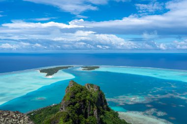 Fransız Polinezyası 'nın Maupiti adasındaki Teurafaatiu Dağı' ndan nefes kesici bir panoramik manzara, bu uzak cennetin turkuaz lagün, mercan resifleri, motus ve yemyeşil manzaralarını gözler önüne seriyor.