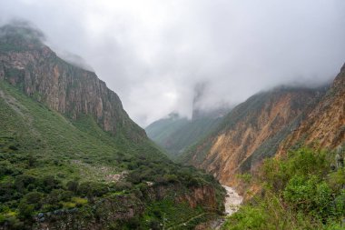 Peru 'daki Colca Kanyonu' nun ve nehrin büyüleyici manzarasını saran sis, sarp dağlar ve dağlarla kaplıyor.