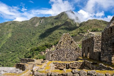 Çimenli yeşil teraslar ve Machu Picchu 'nun içinde parlak And gökyüzünün altında oyulmuş taş duvarlar.