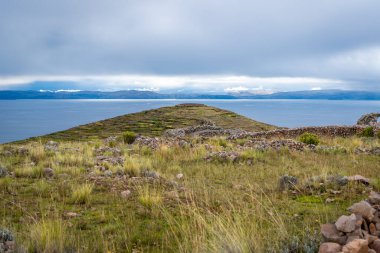 Peru 'nun Amantani Adası' ndaki kutsal Pachatata dağında Titicaca Gölü 'ne bakan antik teraslar ve bulutlu gökyüzünün altındaki zirvesinde tarihi bir arkeolojik alan bulunur.