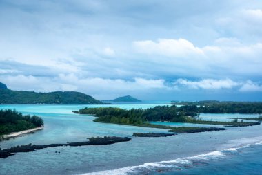 Büyüleyici Bora Bora adasının hava manzarası kristal berrak sularını, bereketli dağlarını ve Fransız Polinezyası 'ndaki mercan resiflerini gösteriyor.