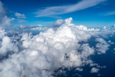 Görkemli beyaz bulutlar derin mavi Pasifik Okyanusu 'nun üzerinde yüzerler, Fransız Polinezyası üzerinde uçan bir uçaktan yakalanırlar. Nefes kesici yüksek irtifa perspektifi