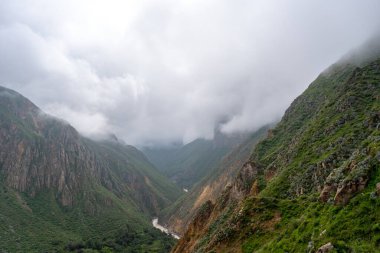Peru 'daki Colca Kanyonu' nun ve nehrin büyüleyici manzarasını saran sis, sarp dağlar ve dağlarla kaplıyor.