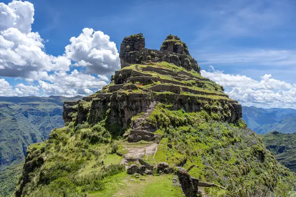 Peru 'daki Waqrapukara arkeolojik sahasında engebeli bir dağ zirvesinde, Andean manzarasının çarpıcı manzaralarını sunan teraslı taş kalıntıları yer almaktadır.