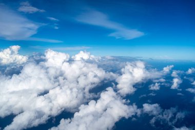 Görkemli beyaz bulutlar derin mavi Pasifik Okyanusu 'nun üzerinde yüzerler, Fransız Polinezyası üzerinde uçan bir uçaktan yakalanırlar. Nefes kesici yüksek irtifa perspektifi