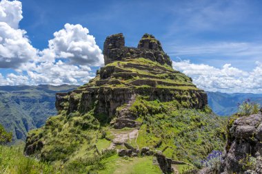 Peru 'daki Waqrapukara arkeolojik sahasında engebeli bir dağ zirvesinde, Andean manzarasının çarpıcı manzaralarını sunan teraslı taş kalıntıları yer almaktadır.