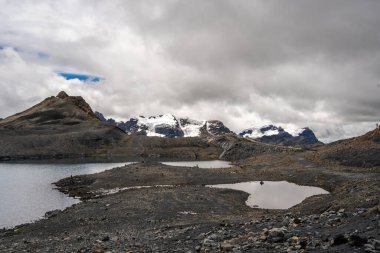 Huaraz, Peru 'da çarpıcı bir yüksek irtifa buz oluşumu olan Pastoruri Buzulu küçük bir buzul gölüne yansıyor. Bu geri çekilen buzullar, iklim değişikliğinin And arazisi üzerindeki etkilerini vurguluyor ve bölgede önemli bir yürüyüş noktası haline geliyor.