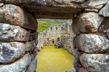 Çimenli yeşil teraslar ve Machu Picchu 'nun içinde parlak And gökyüzünün altında oyulmuş taş duvarlar.