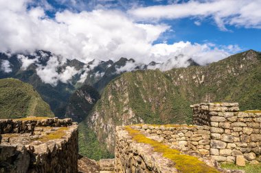 Çimenli yeşil teraslar ve Machu Picchu 'nun içinde parlak And gökyüzünün altında oyulmuş taş duvarlar.