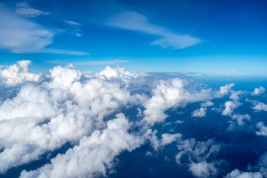 Görkemli beyaz bulutlar derin mavi Pasifik Okyanusu 'nun üzerinde yüzerler, Fransız Polinezyası üzerinde uçan bir uçaktan yakalanırlar. Nefes kesici yüksek irtifa perspektifi