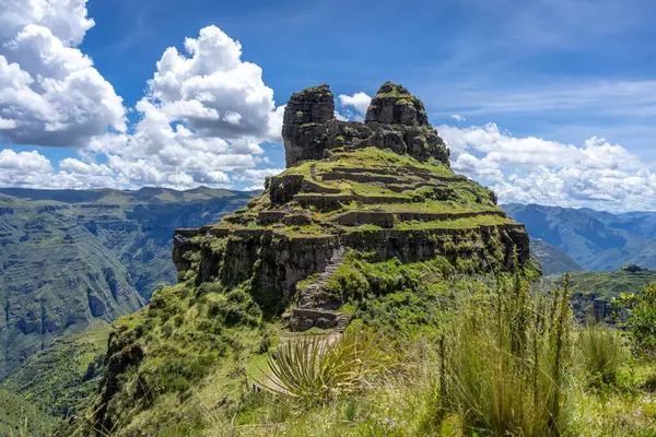 Peru 'daki Waqrapukara arkeolojik sahasında engebeli bir dağ zirvesinde, Andean manzarasının çarpıcı manzaralarını sunan teraslı taş kalıntıları yer almaktadır.