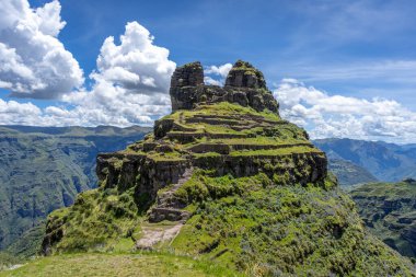 Peru 'daki Waqrapukara arkeolojik sahasında engebeli bir dağ zirvesinde, Andean manzarasının çarpıcı manzaralarını sunan teraslı taş kalıntıları yer almaktadır.
