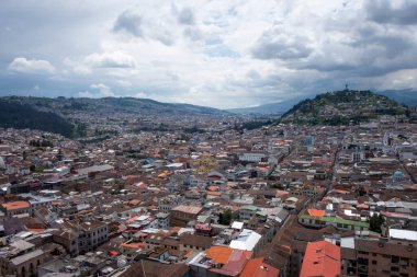 Quito, Ekvador 'un geniş açılı görüntüsü, aşağıdaki şehir manzarası ve tepedeki sembolik El Panecillo heykeli.