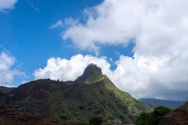 Hiva Oa, Marquesas Adaları, Fransız Polinezyası 'ndaki Puamau yolu boyunca uzanan dağlık arazi engebeli zirveleri ve derin vadileriyle yoğun tropikal bitki örtüsüyle kaplıdır.