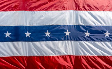 Kırmızı, beyaz ve mavi çizgili vatansever bir bayrak. Merkezi mavi bölümde Amerikan gurur ve geleneğini sembolize eden beyaz yıldızlar yer almaktadır. ABD