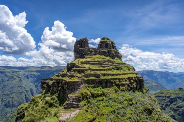 Peru 'daki Waqrapukara arkeolojik sahasında engebeli bir dağ zirvesinde, Andean manzarasının çarpıcı manzaralarını sunan teraslı taş kalıntıları yer almaktadır.