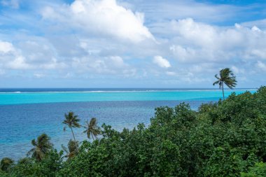Huahine, Fransız Polinezyası 'ndaki Tefarerii bakış açısı, engin bir gökyüzü altında turkuaz gölünün, derin mavi okyanusun ve yemyeşil tropikal bitkilerin nefes kesici bir görüntüsünü sunar.
