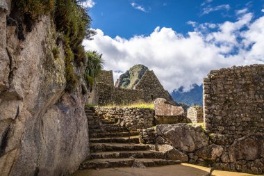Çimenli yeşil teraslar ve Machu Picchu 'nun içinde parlak And gökyüzünün altında oyulmuş taş duvarlar.