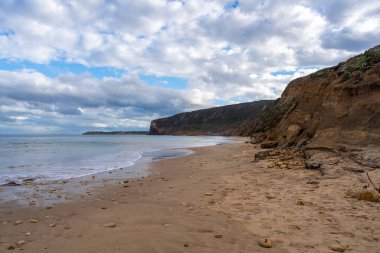 Avustralya 'nın Büyük Okyanus Yolu üzerindeki Aireys Körfezi' ndeki Bells Beach 'te altın kum, dağınık kayalar ve yüksek uçurumlar bulunur. Mavi okyanus dramatik bulutlarla dolu uçsuz bucaksız bir gökyüzü ile karşılaşıyor, çarpıcı bir kıyı manzarası yaratıyor.