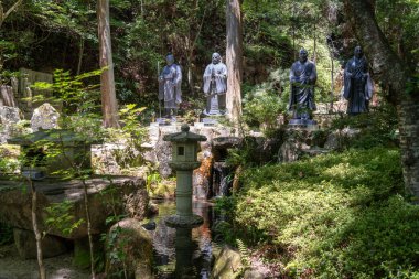 Hiroşima 'daki Mitaki-Dera Tapınağı' nın ormanlarında ağırbaşlı bir şekilde duran uzun bronz keşiş heykelleri barış ve hürmet saçıyor.