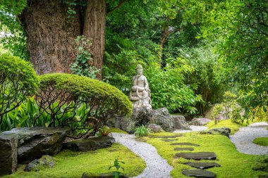 Kannon 'un sakin heykeli, Kamakura' daki Hokoku-ji türbesindeki ağaçlar ve taşlarla çevrili yosun kaplı zen bahçesinde duruyor.