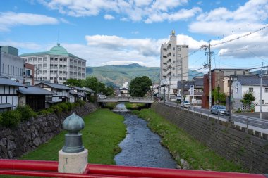 Geleneksel evler, modern binalar ve dağlarla çevrili Japonya 'daki Matsumoto şehrinden akan Metoba Nehri' nin huzurlu manzarası