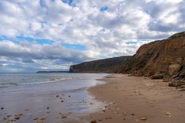 Avustralya 'nın Büyük Okyanus Yolu üzerindeki Aireys Körfezi' ndeki Bells Beach 'te altın kum, dağınık kayalar ve yüksek uçurumlar bulunur. Mavi okyanus dramatik bulutlarla dolu uçsuz bucaksız bir gökyüzü ile karşılaşıyor, çarpıcı bir kıyı manzarası yaratıyor.