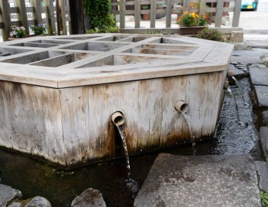 Kristal berrak kaynak suyu, Matsumoto 'daki geleneksel bir ahşap kuyudan tatlı bir şekilde akar ve büyüleyici bir ortamda ferahlık ve huzur sunar.
