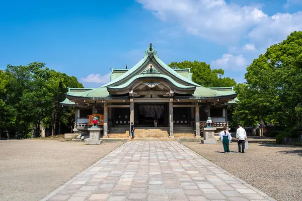 Osaka 'daki Hokoku Tapınağı' nın ana salonunda zarif kıvrımlı çatılar, geleneksel ahşap yapılar ve berrak bir yaz gökyüzü altında huzurlu çevreler yer almaktadır.