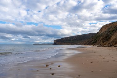 Avustralya 'nın Büyük Okyanus Yolu üzerindeki Aireys Körfezi' ndeki Bells Beach 'te altın kum, dağınık kayalar ve yüksek uçurumlar bulunur. Mavi okyanus dramatik bulutlarla dolu uçsuz bucaksız bir gökyüzü ile karşılaşıyor, çarpıcı bir kıyı manzarası yaratıyor.