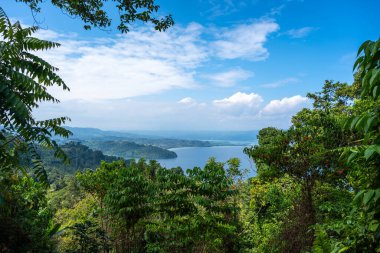 Tentena, Sulawesi, Endonezya yakınlarındaki açık mavi gökyüzünün altında yemyeşil tepeler ve ormanlarla çevrili Poso Gölü geniş bir görüş alanına sahiptir.