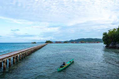 Turkuaz suların üzerinden Malenge Adası 'ndaki geleneksel Bajo köyü Pulau Papan' a uzanan uzun tahta bir iskele var.