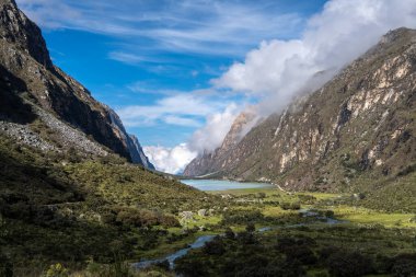 Yükselen dağlar arasında yemyeşil bir vadi uzanır, sakin bir göle uzanan dolambaçlı bir nehir. Bu nefes kesici manzara, Peru, Huaraz 'daki Laguna 69 yürüyüşünün bir parçası.